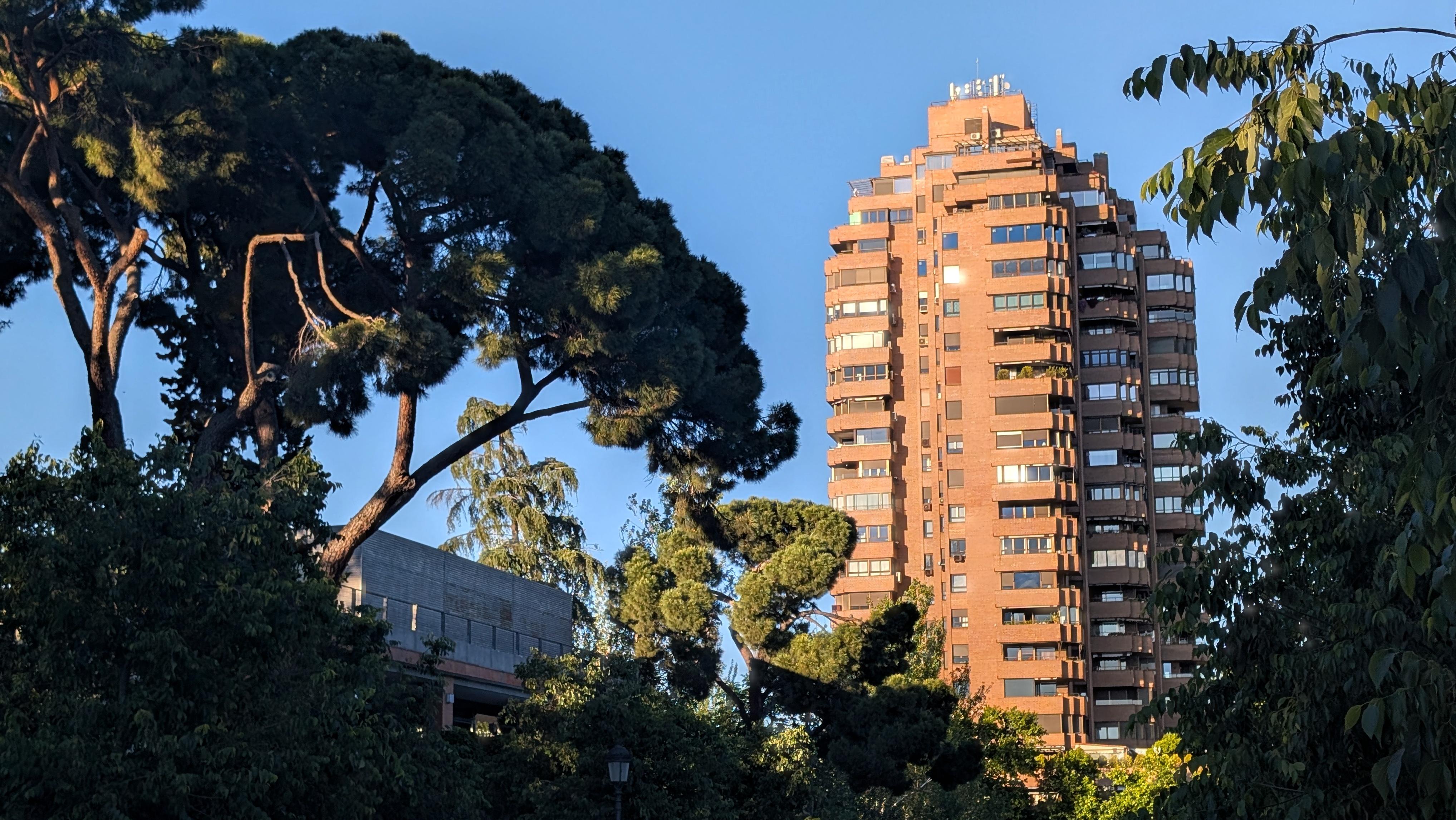 Rising above the trees of Parque del Retiro, the Torre de Valencia is a striking residential high-rise with a reddish façade. Designed by Javier Carvajal in the early 1970s, it stands around 94 metres tall and was controversial at the time for its bold placement near the Retiro and the Puerta de Alcalá. Today it creates a fascinating contrast between urban architecture and the quiet parkland around it.