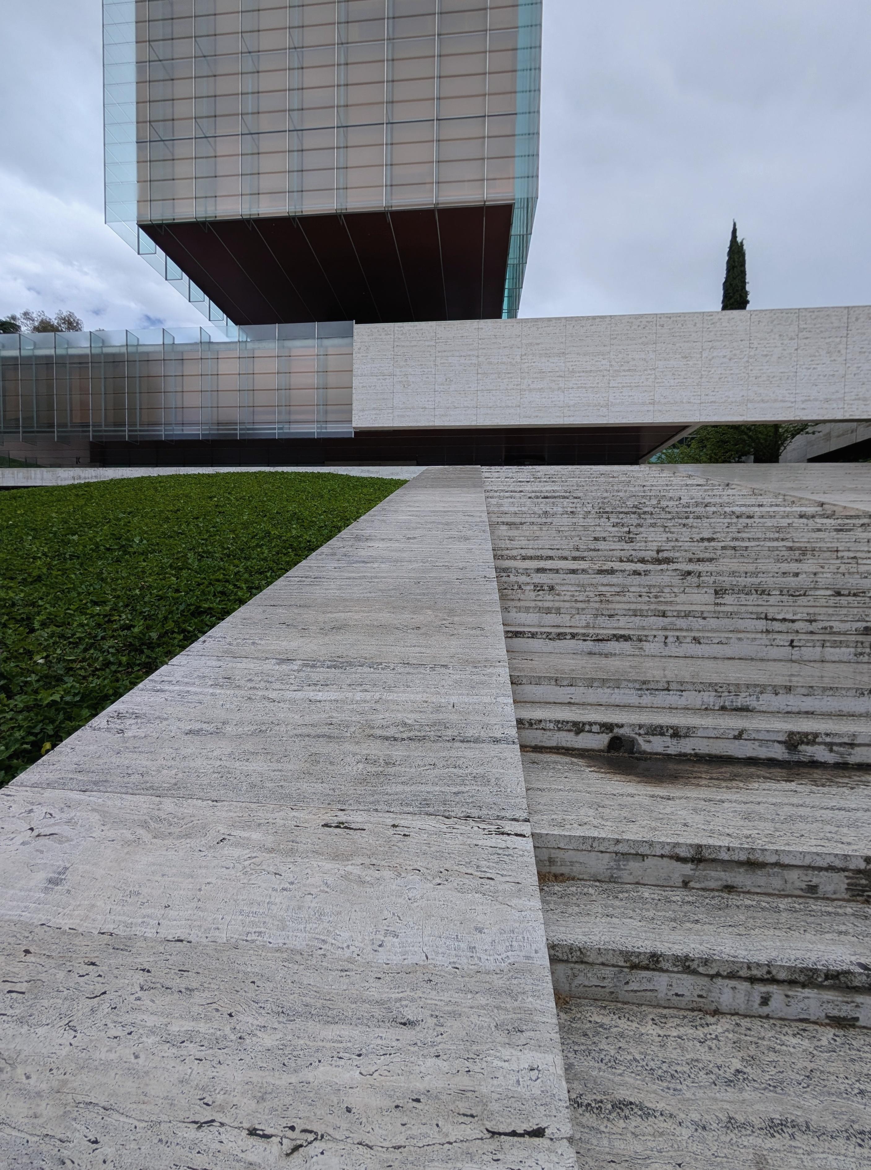 The Edificio Castelar on the Paseo de la Castellana looks as though its glass body is floating above a pale travertine base. It was designed by Rafael de La-Hoz Arderius and Gerardo Olivares and originally built between 1977 and 1983. For Madrid at the time, the building was architecturally daring, large portions of the office floors hang from an unusual load-bearing structure, giving the whole thing a light, almost futuristic quality. It was later renovated by Rafael de La-Hoz Castanys, son of the original architect. Today the Edificio Castelar is considered one of the defining examples of modern architecture along the Castellana.