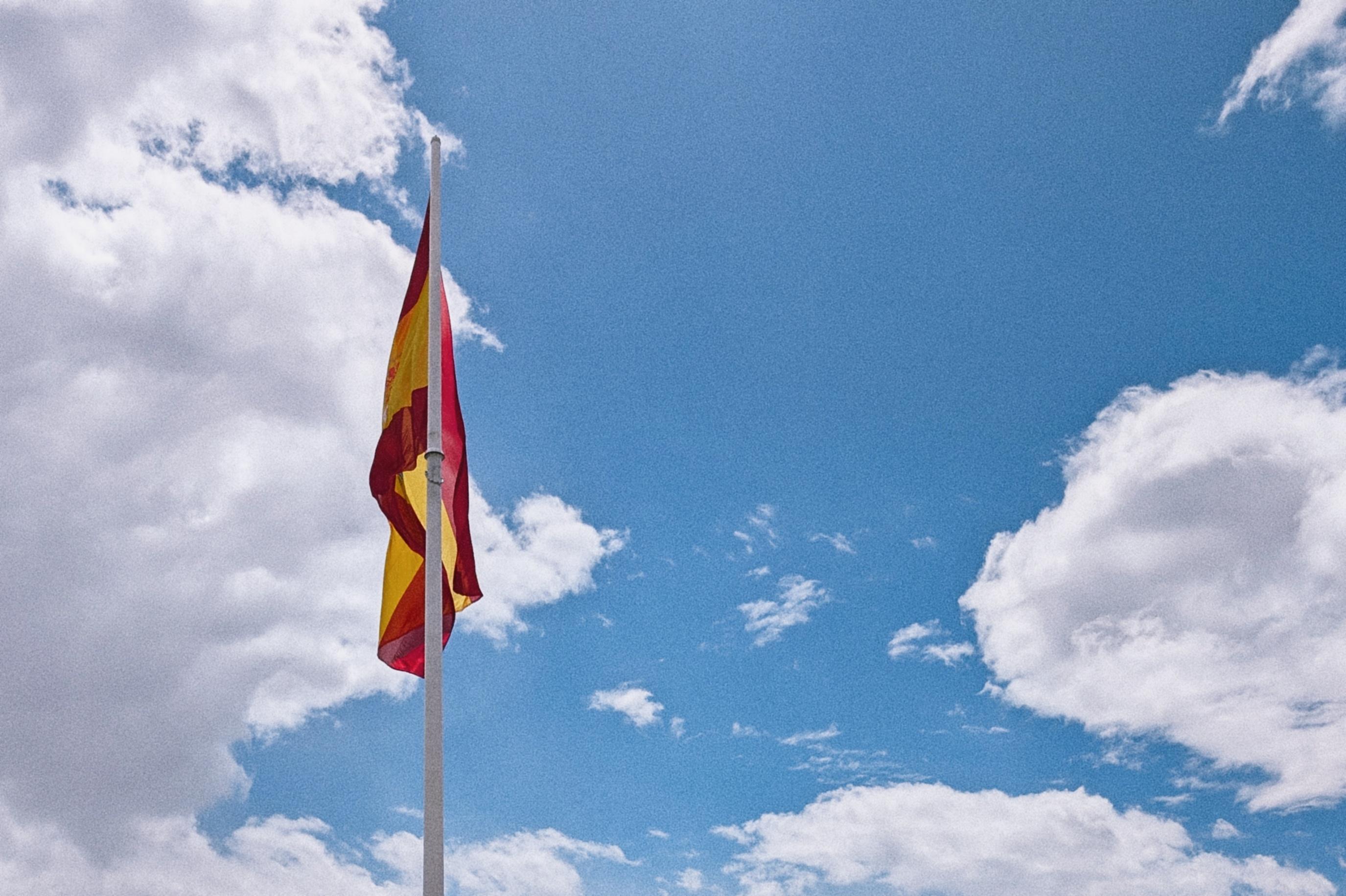 Spanish without a tailwind – The photo shows the large Spanish flag at Plaza de Colón in Madrid. It stands near the Jardines del Descubrimiento, hoisted on a flagpole roughly 50 metres tall. The flag itself measures approximately 21 metres wide and 14 metres high — about 294 square metres in total. That makes it one of the most striking landmarks on this square.